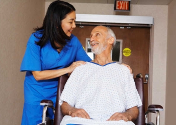 Nurse with Senior Man in Wheelchair --- Image by © Artiga Photo/Corbis