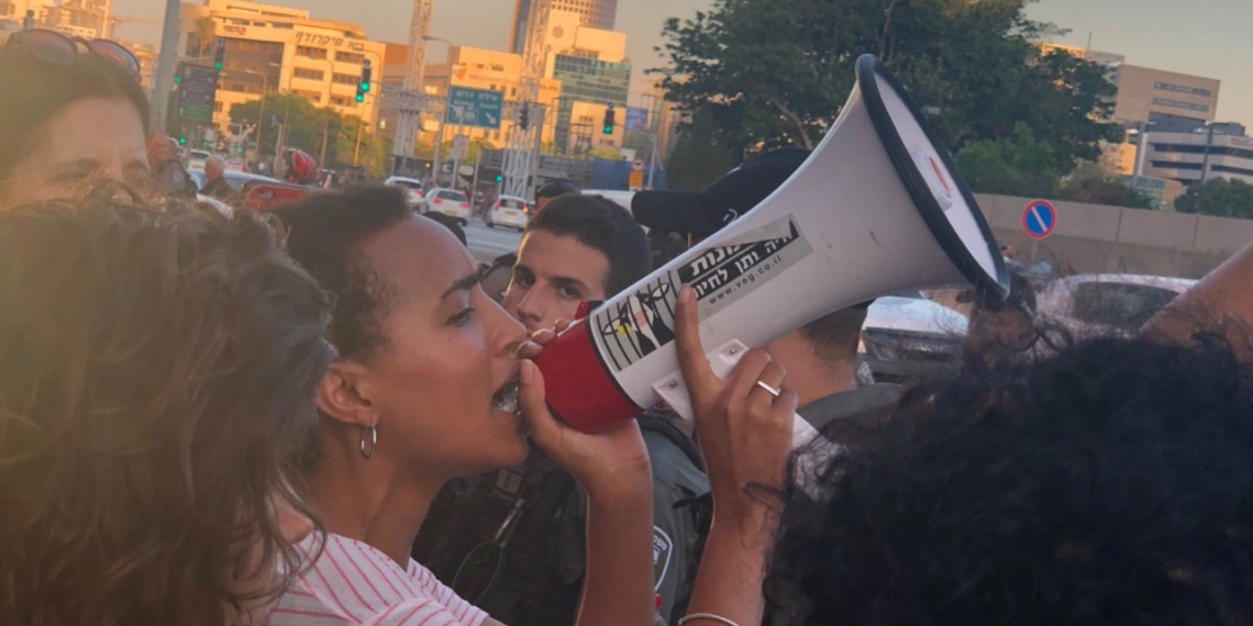 "צאו מהמרפסת - האדישות הורגת". אחת המפגינות השבוע