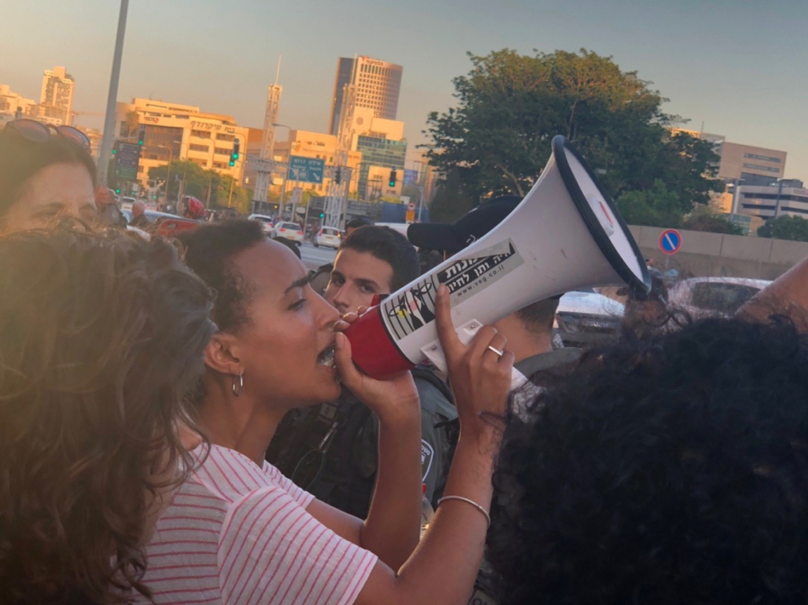 "צאו מהמרפסת - האדישות הורגת". אחת המפגינות השבוע