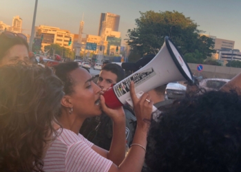 "צאו מהמרפסת - האדישות הורגת". אחת המפגינות השבוע