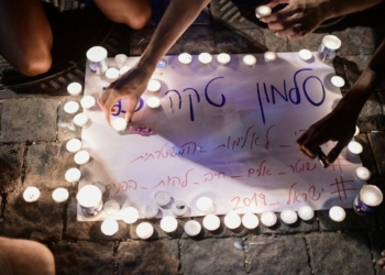 נערים מדליקים נרות לזכרו של טקה במקום הירצחו, ביולי האחרון | צילום:תומר נויברג, פלאש 90