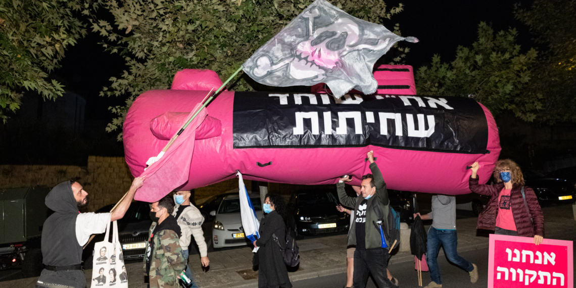 דניאל פלנקר מניף דגל פיראטים בצעדה | צילום: מולי גולדברג