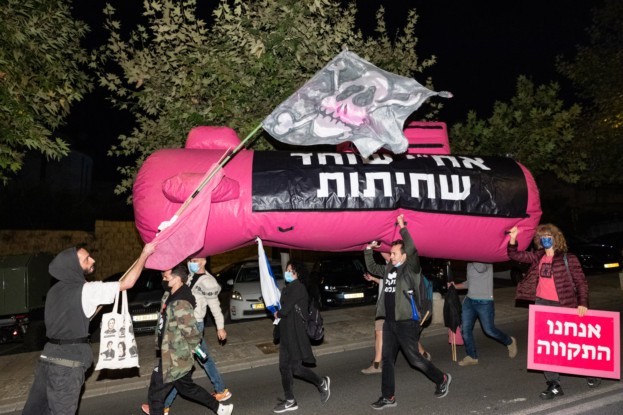 דניאל פלנקר מניף דגל פיראטים בצעדה | צילום: מולי גולדברג