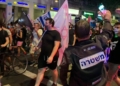 שוטר מצלם מפגינים בצעדה בתל אביב לפני כשבועיים
