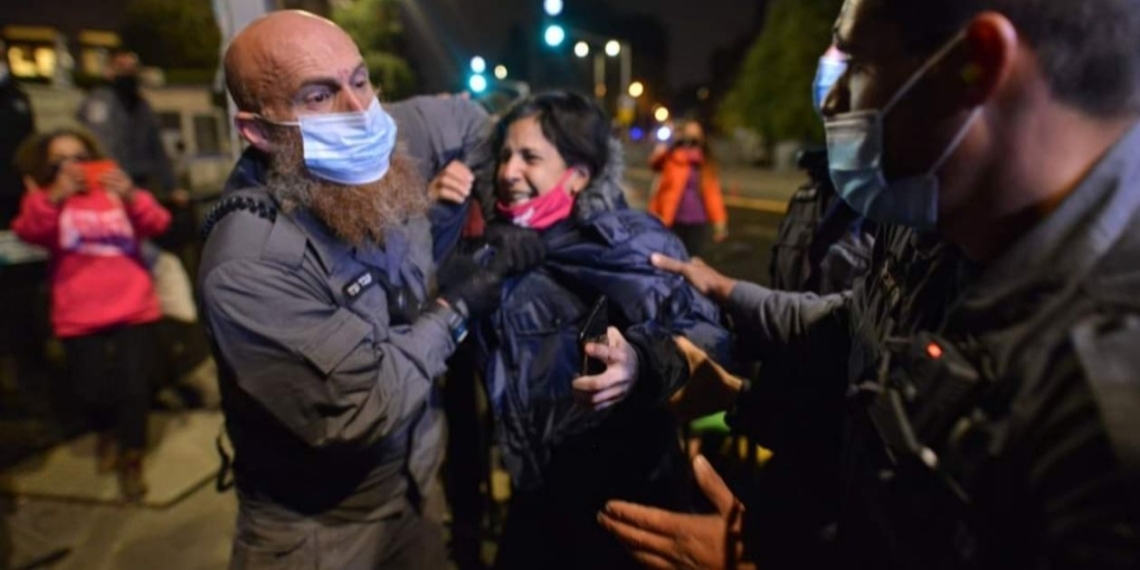 עבד נערני עוצר את אחת המפגינות | צילום: מתן גולן