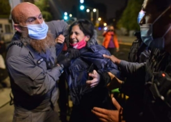 עבד נערני עוצר את אחת המפגינות | צילום: מתן גולן