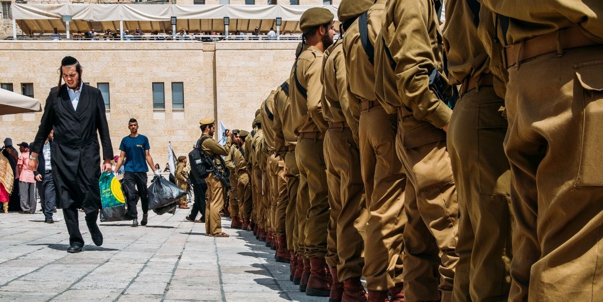 צעיר חרדי צועד ליד חיילים | צילום: שאטרסטוק