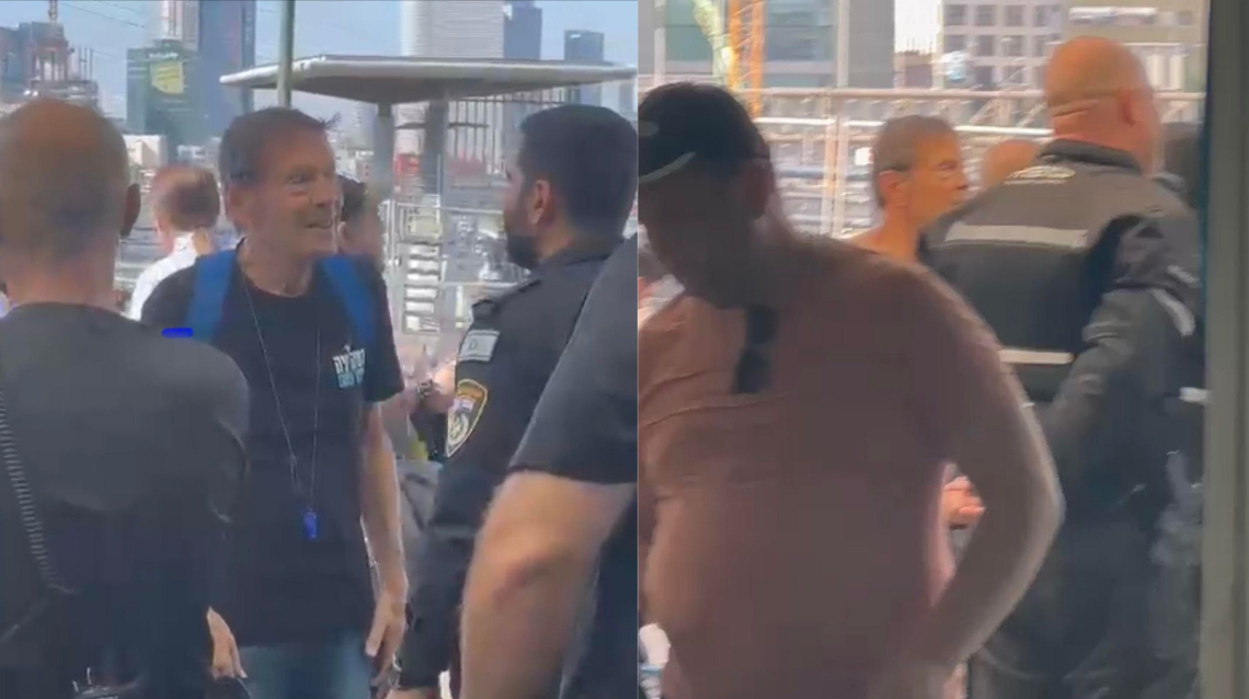 נוסע שנדרש להפוך חולצה עם הכיתוב "דמוקרטיה" בתחנת רכבת ההגנה | צילום: דור זומר