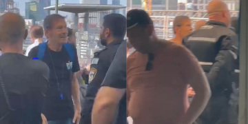 נוסע שנדרש להפוך חולצה עם הכיתוב "דמוקרטיה" בתחנת רכבת ההגנה | צילום: דור זומר