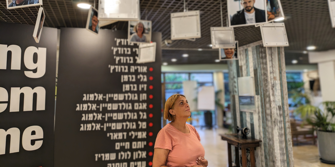 חברת הכנסת לשעבר נירה שפק עם תמונות החטופים מכפר עזה, בכפר הנופש שפיים | צילום: נתן רושנסקי