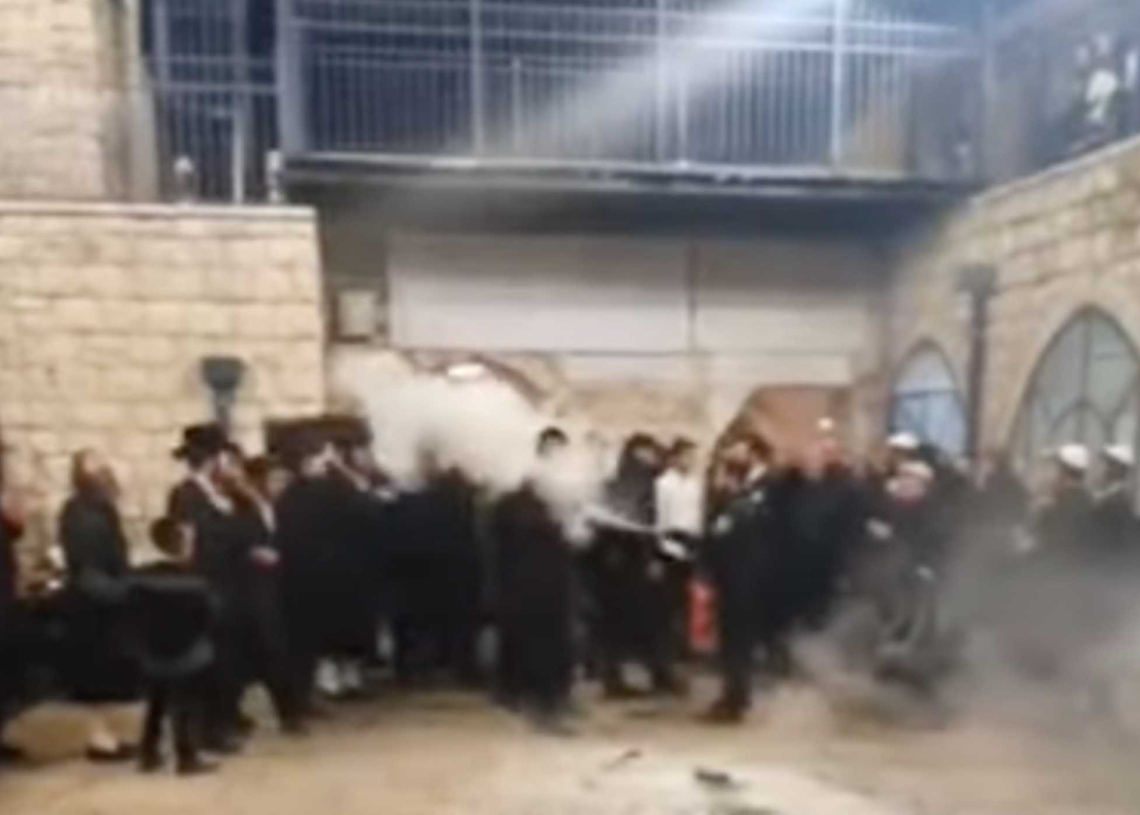 שוטר מתיז חומרי כיבוי על חרדים במירון צילום מסך מתוך יוטיוב