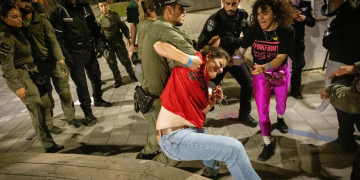 שוטרים גוררים את איילה מצגר על המדרכה בסמוך למעון רה״מ (צילום: חיים גולדברג, פלאש 90)