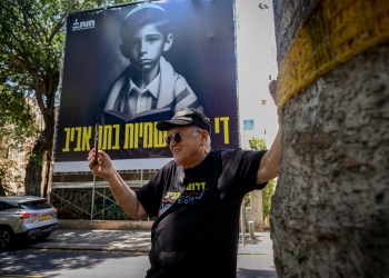 פז על רקע השלט ״די לאנטישמיות בתל אביב״ בשדרות רוטשילד | צילום: אבשלום ששוני, פלאש 90