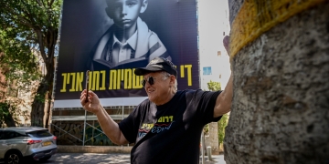 פז על רקע השלט ״די לאנטישמיות בתל אביב״ בשדרות רוטשילד | צילום: אבשלום ששוני, פלאש 90