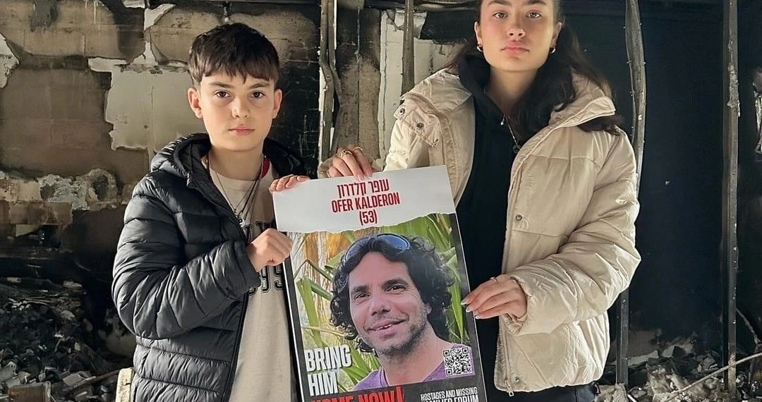 סהר (17) וארז (12) ששוחררו משבי חמאס בנובמבר ותמונת אביהם, עופר קלדרון, שעדיין בעזה