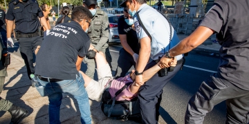 סייר ביטחון של עיריית ירושלים מסייע למשטרה לפנות מאהל מחאה נגד הממשלה (צילום: יונתן סינדל, פלאש 90)