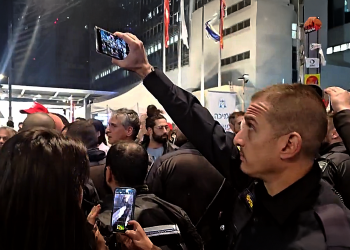 שוטר מצלם מפגינים במחאה למען שחרור החטופים בתל אביב | תיעוד: xלימות ישראל