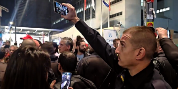 שוטר מצלם מפגינים במחאה למען שחרור החטופים בתל אביב | תיעוד: xלימות ישראל