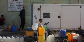 נער בתור לקבלת מי שתייה ברצועת עזה | צילום: עלי חסאן, פלאש 90