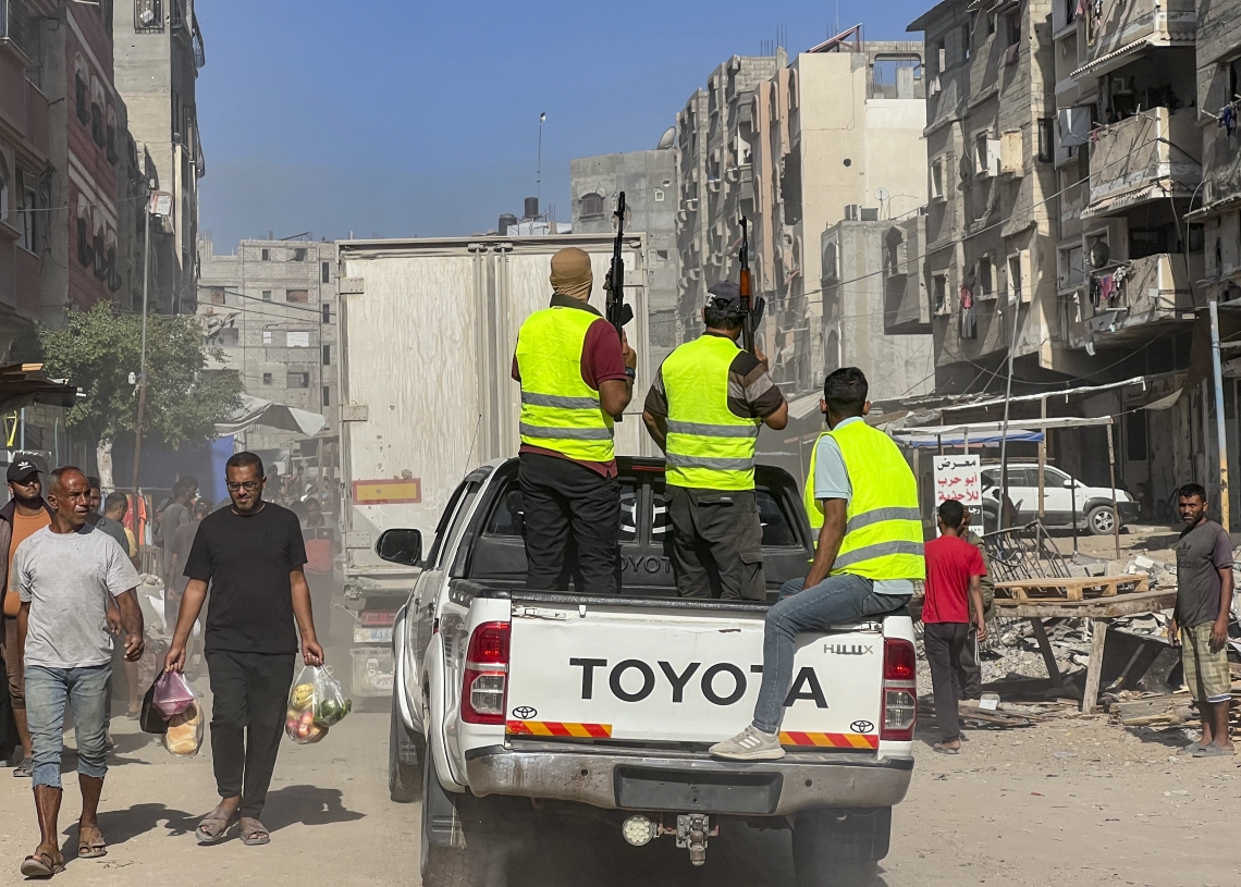 חמושים מאבטחים את משאיות הסיוע ההומניטרי שנכנסו לרצועה במסגרת ההסכם, בשבת שעברה בחאן יונס | צילום:  Saeed Mohammed/Flash90