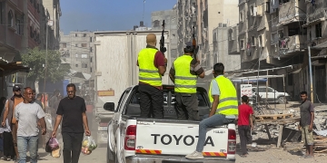 חמושים מאבטחים את משאיות הסיוע ההומניטרי שנכנסו לרצועה במסגרת ההסכם, בשבת שעברה בחאן יונס | צילום:  Saeed Mohammed/Flash90