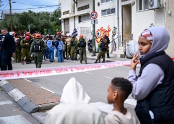 מבקשי מקלט על רקע זירת פגיעה של פצצת מצרר מאיראן בדרום תל אביב הבוקר | צילום: אבשלום ששוני, פלאש 90