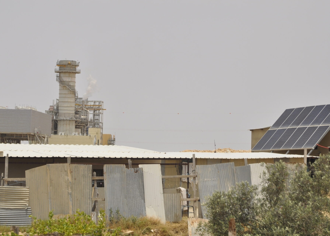 בית בכפר ואדי אל-נעם וברקע תחנת הכוח "אורות יוסף" (צילום: יעל געתון)