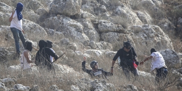 מתנחלים יהודים תוקפים עיתונאים במהלך עונת קטיף הזיתים בכפר ביתה, מדרום לשכם בגדה המערבית, 8 בנובמבר 2025. צילום: נאצר אשתייה/Flash90