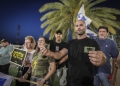 אנשים עם דגלי ישראל וסמלי ״משיח״ מפגינים כנגד מאסר של חייל על לבישת פאץ׳ משיח