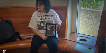 מירי דגן באולם בג"ץ במהלך הדיון על הכרה בחיילים שהתאבדו כחללי צה"ל, מחזיקה תמונה של בנה אסף דגן ז"ל | צילום: סיון תהל
