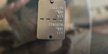 מירי דגן אוחזת בדיסקית של בנה אסף ששם קץ לחייו ב-2024 והוכר רק אחרי מאבק ממושך | צילום: סיון תהל