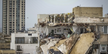 אנשי פיקוד העורף זמן קצר לאחר הקריסה בדרך יפו 44. משעה שהבהירו שלא מדובר בנזקי טיל איראני החלה מסכת ההתנערות | צילום: פלאש 90