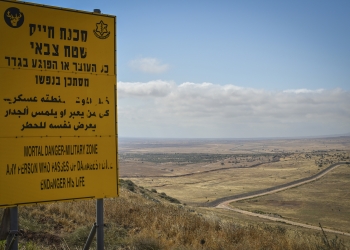 הגבול עם סוריה, ברקע נוף צחיח ותמרור גדול עם כיתוב מופיע בצד שמאל