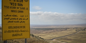 הגבול עם סוריה, ברקע נוף צחיח ותמרור גדול עם כיתוב מופיע בצד שמאל