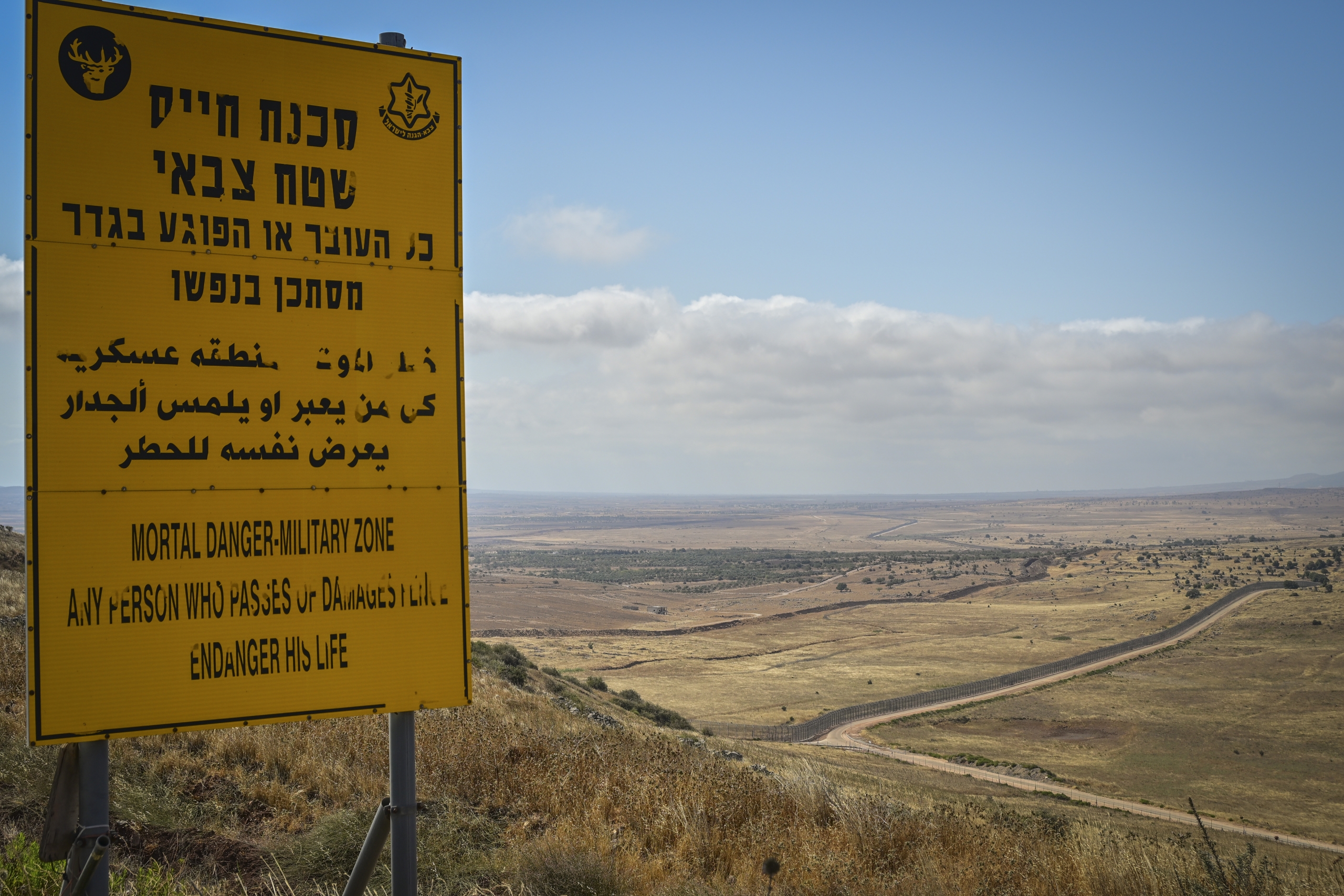 הגבול עם סוריה, ברקע נוף צחיח ותמרור גדול עם כיתוב מופיע בצד שמאל