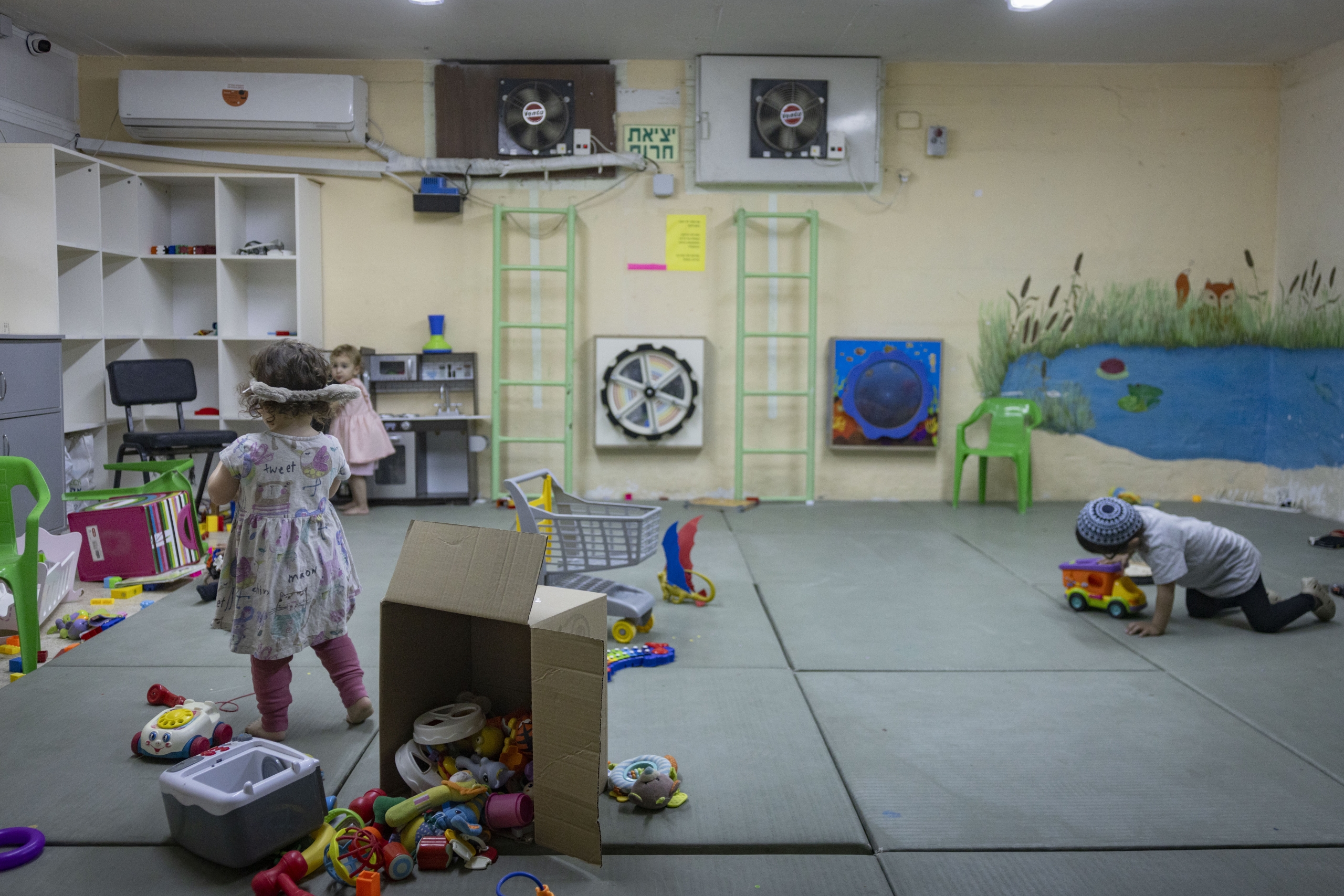 שלושה ילדים קטנים משחקים במקלט צבעוני בירושלים