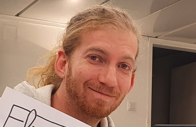 גבר בלונדיני מחייך למצלמה. טל רוזנבליט
